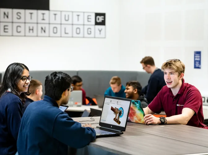 Students working on laptops in the common room