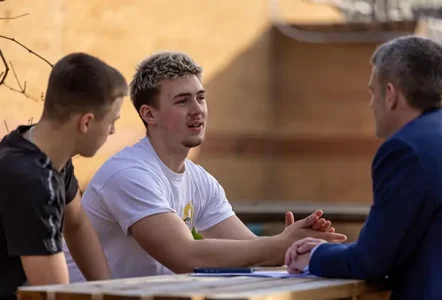 Two students talking to employer