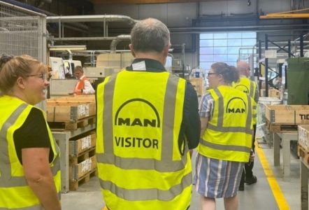 Visitors in a factory wearing high visibility clothing