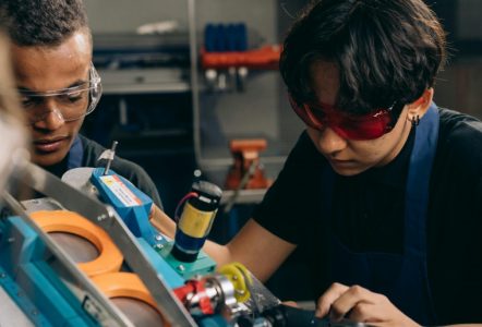 A young person in a workshop operating equipement