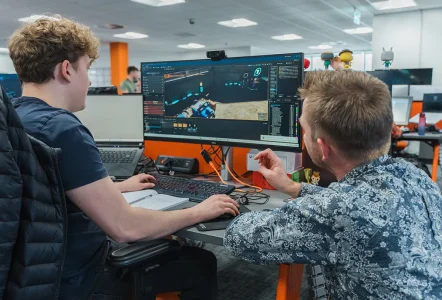 A student doing 3D modelling work in a lab, being helped by their tutor
