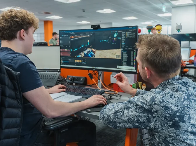 A student doing 3D modelling work in a lab, being helped by their tutor