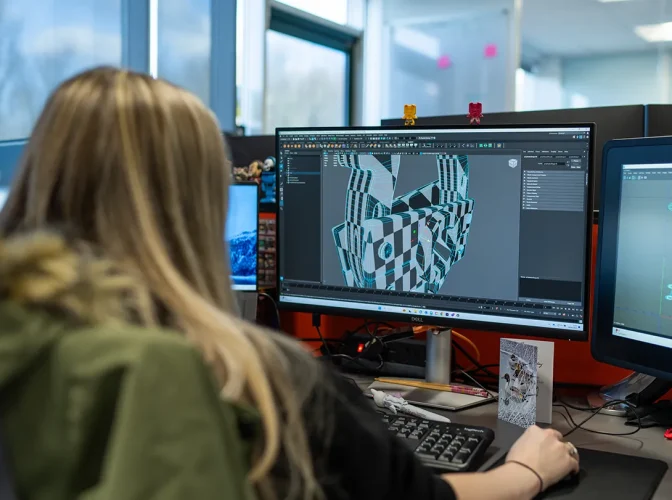 A technician looking at a 3D modelling tool on a computer