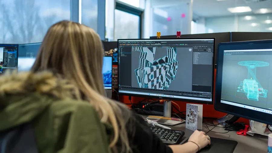 A technician looking at a 3D modelling tool on a computer
