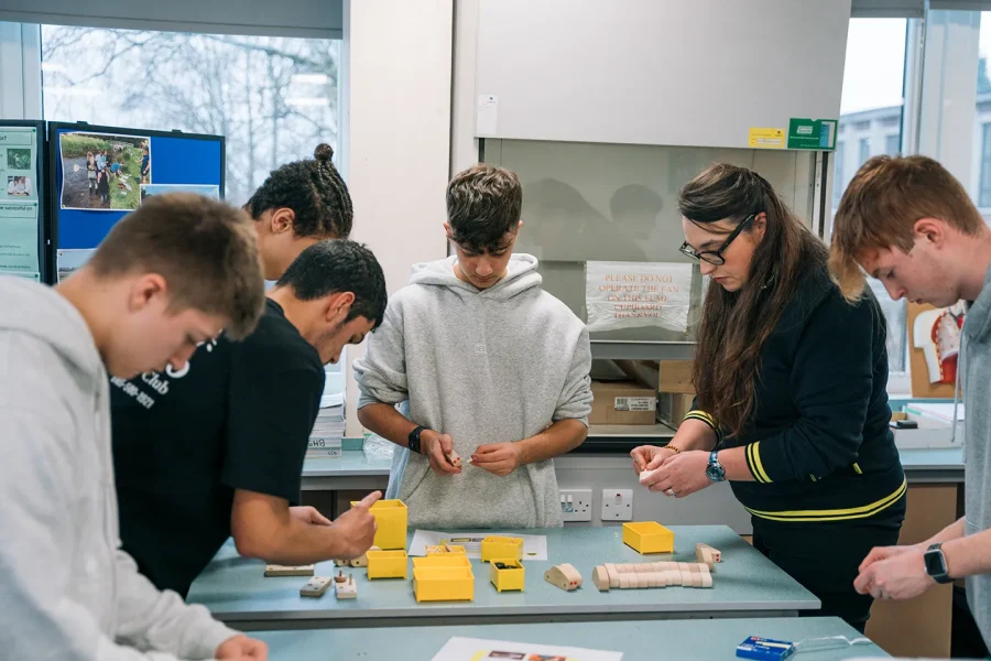 A teacher helping a group of students completing an activity