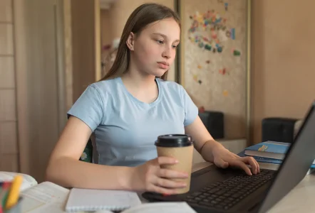 Teenage girl learning on a laptop at home