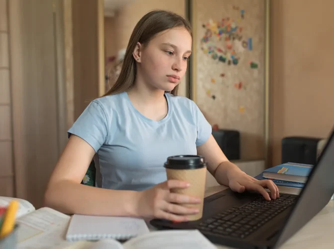 Teenage girl learning on a laptop at home