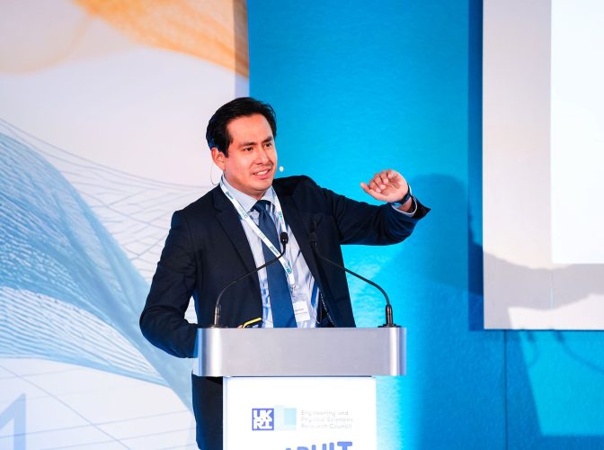 Dr Carlos Lopez-Gomez stands at podium, presenting at a conference